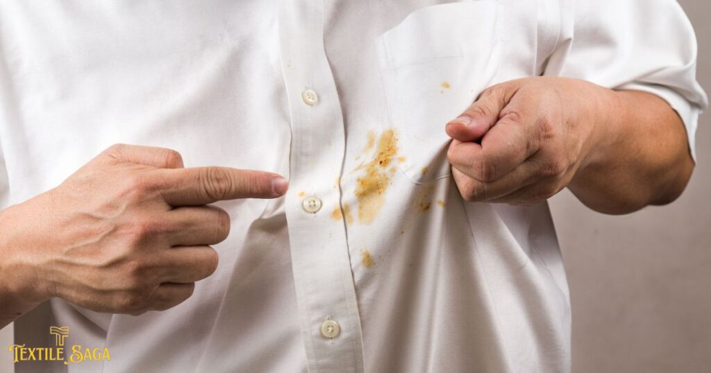 The man is pointing toward's the stains on his clothes.